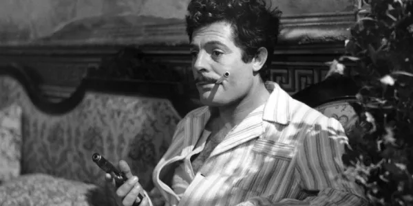   Ferdinando Cefalù が銃を持ち、イタリア式の離婚でタバコを吸う