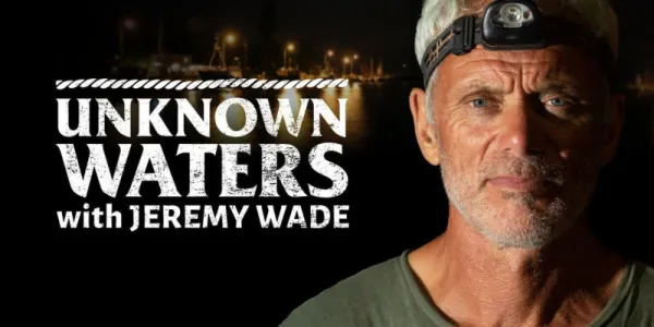   ジェレミー・ウェイドとのドキュメンタリー「未知の海」のバナーに立つジェレミー・ウェイド。